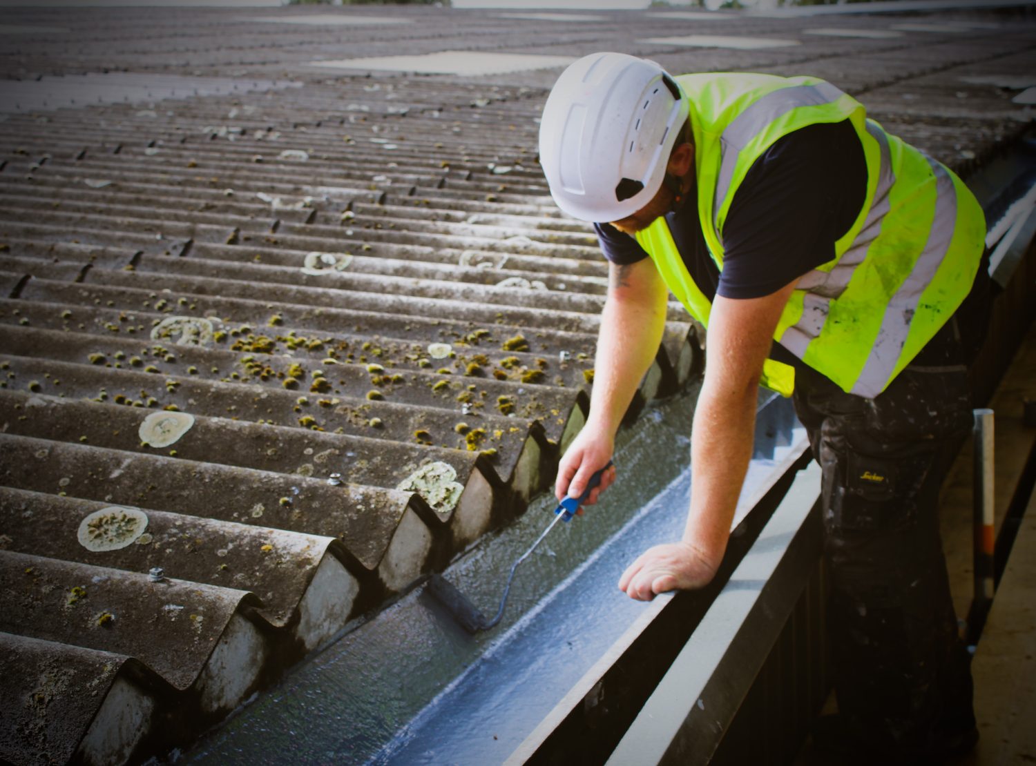 Evermax operative in high visibility clothing working on a commercial roof from scaffold