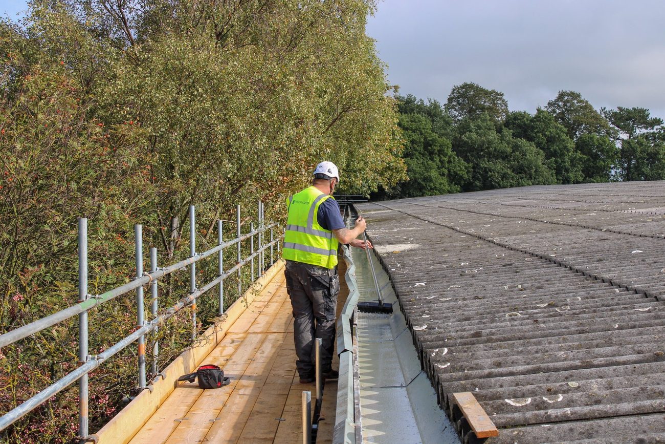 Evermax operative clearing a parapet gutter during a planned maintenance visit